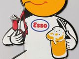 a picture of a sign that says esso with a man holding a glass of beer