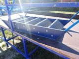 a blue metal bench that is on the side of the road