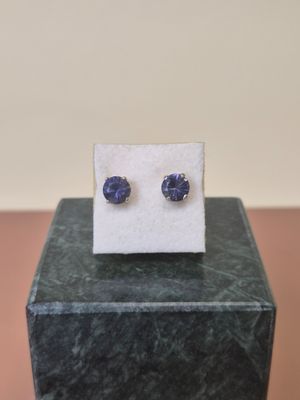 a pair of blue sapphire earrings sitting on top of a marble block