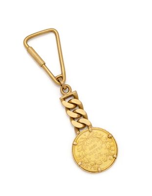 a gold key chain with a coin on it