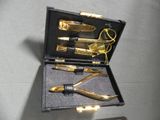 a black case with a gold pen, scissors, and a pair of scissors