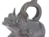 une figurine noire représentant un taureau coiffé d'un haut-de-forme