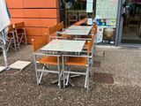 tables and chairs outside of a restaurant with an umbrella