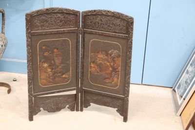 deux paravents en bois ornés de peintures dans une pièce
