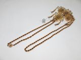 bijou de tête plaqué or, orné de perles et de chaînes, sur un fond blanc