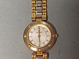 une montre-bracelet en or et en argent posée sur une table