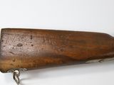 an old wooden rifle mounted to a wall on a white surface