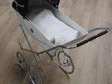 une poussette posée sur un plancher en bois