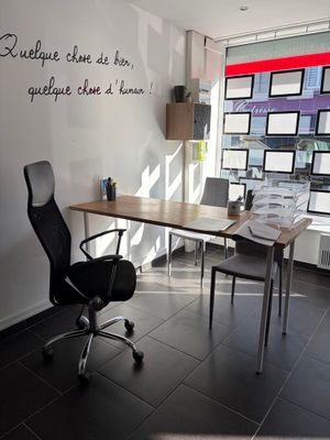 un bureau avec une chaise devant une fenêtre