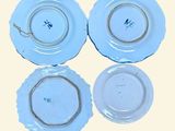 three blue plates with white designs on them on a yellow background