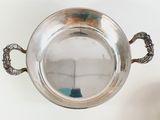 a silver bowl with handles on a white table