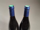 two bottles of wine sitting next to each other on a table