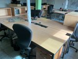 tables and chairs in an office with a computer on top of them