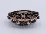 silver and gold bracelet with pearls on a white background