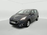 La voiture grise est garée dans une pièce blanche au sol blanc.