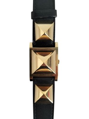 the watch is made of black leather with gold pyramids on it