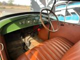a green and brown car with a steering wheel and dashboard
