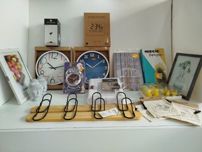 une étagère sur laquelle se trouvent une horloge, des cadres, des photos et d'autres objets