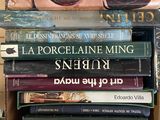 many books stacked on top of each other in a box