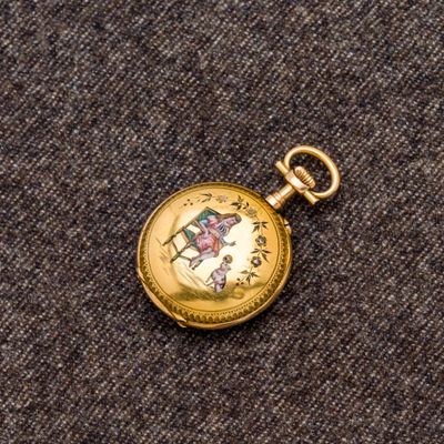 une montre de poche en or sur laquelle est représenté un cheval