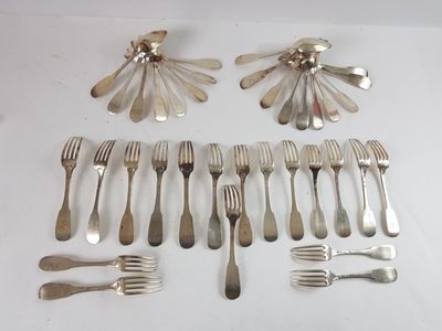 many forks and spoons laid out on the table