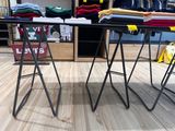 deux tables pliantes sur lesquelles sont posées des chemises pliées, dans un magasin