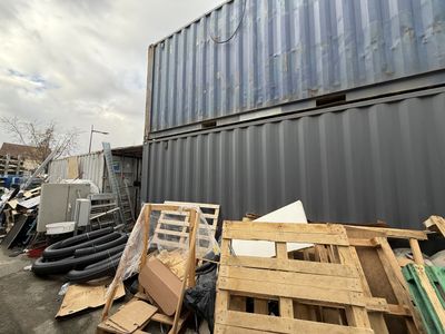 a lot of junk on the ground next to a shipping container
