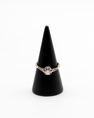 un gros plan d'une bague posée sur un cône, sur fond blanc