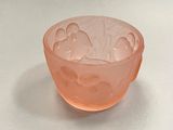 an orange glass bowl with a floral design on it