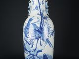 vase bleu et blanc orné d'oiseaux et de fleurs sur fond noir
