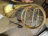 a man holding a brass french horn in his hand