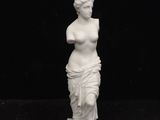a white statue of a woman on a black background