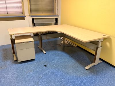 un bureau sur lequel se trouve un ordinateur, dans une pièce vide