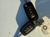 two car keys and a piece of paper on a white surface