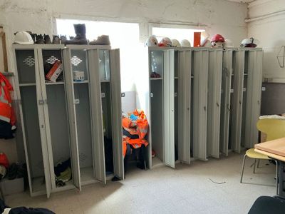 many lockers in a room with a man sitting at a table