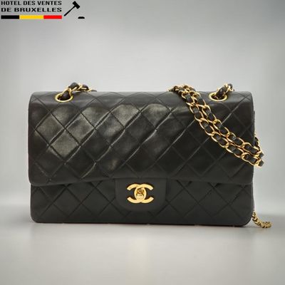 un sac Chanel noir avec des finitions dorées et une chaîne