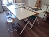 une photo d'une pièce avec une table et des tabourets