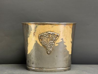 an old silver cup with a grape design on the side