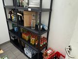 une étagère noire sur laquelle sont posées des bouteilles, dans un coin de la pièce