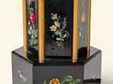une petite boîte noire décorée de fleurs peintes