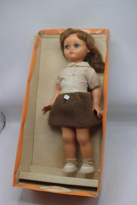 une poupée qui se trouve dans une boîte posée sur une table