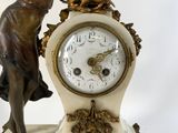 a statue of a woman holding a clock on a table