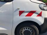 a white van with red and white stripes parked in a parking lot