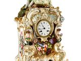 a clock with a figurine of a woman sitting on top of it