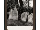 black and white photograph of old tombstones in a cemetery