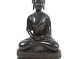 statue of a buddha sitting on a lotus - shaped base