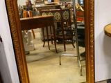 un miroir posé par terre à côté d'une table