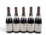 six bouteilles de vin sont alignées sur une surface blanche