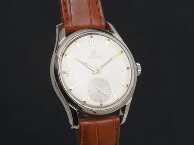 une image représentant une montre argentée avec un bracelet en cuir marron sur fond noir