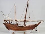 a wooden model of a boat on display on a white surface
